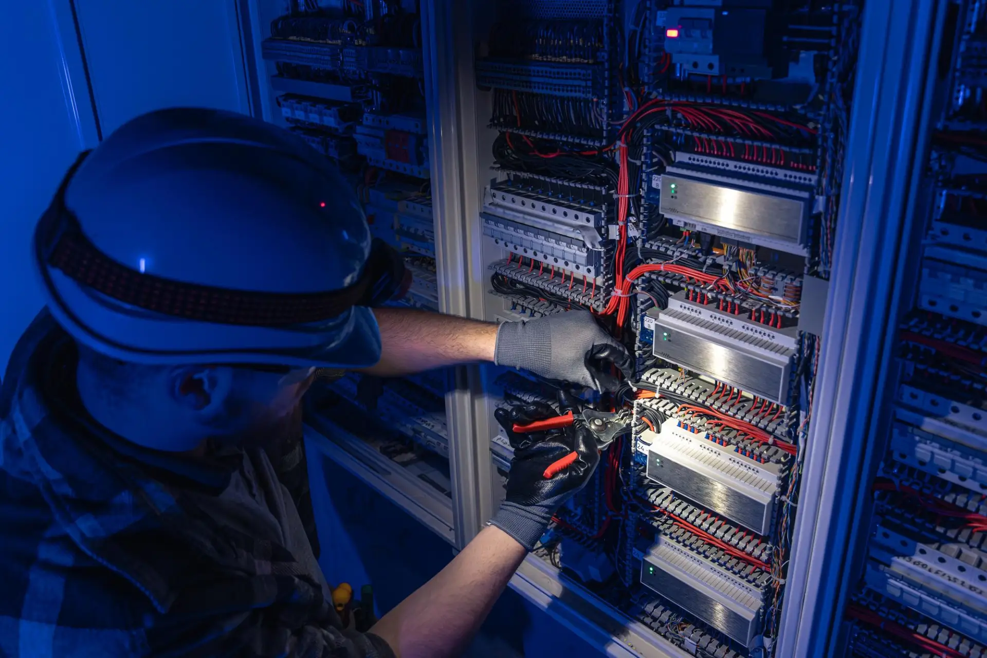 Professional electrician performing electrical work on a commercial electrical panel